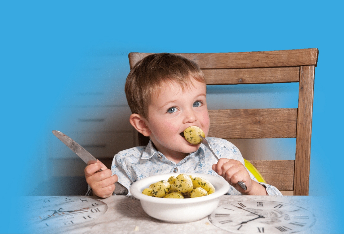 Little boy eating potatoes